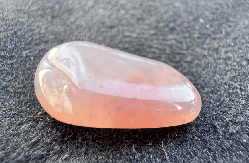 pink hydrogrossular garnet stone polished on a natural background to illustrate a pink stone