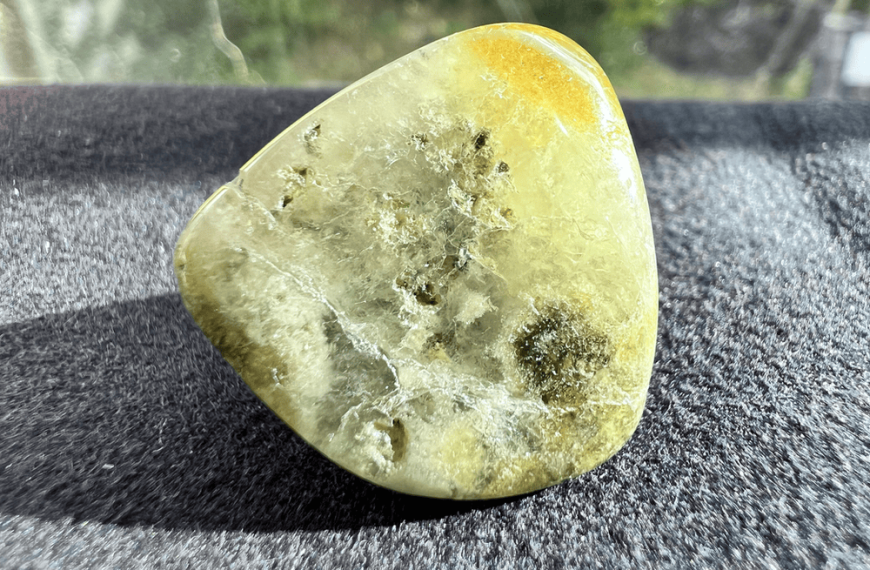 massive green grossular stone in polished stone on a neutral background to illustrate garnet