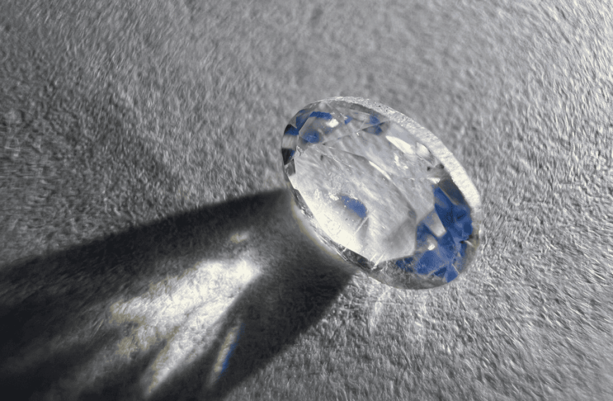 natural cut moonstone showing its transparent blue glow on a white background