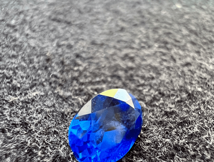 synthetic spinel blue stone on a neutral background to illustrate a blue stone