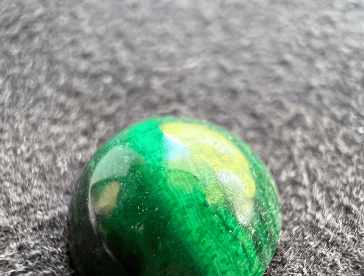 green malachite stone on a neutral background to illustrate a green stone